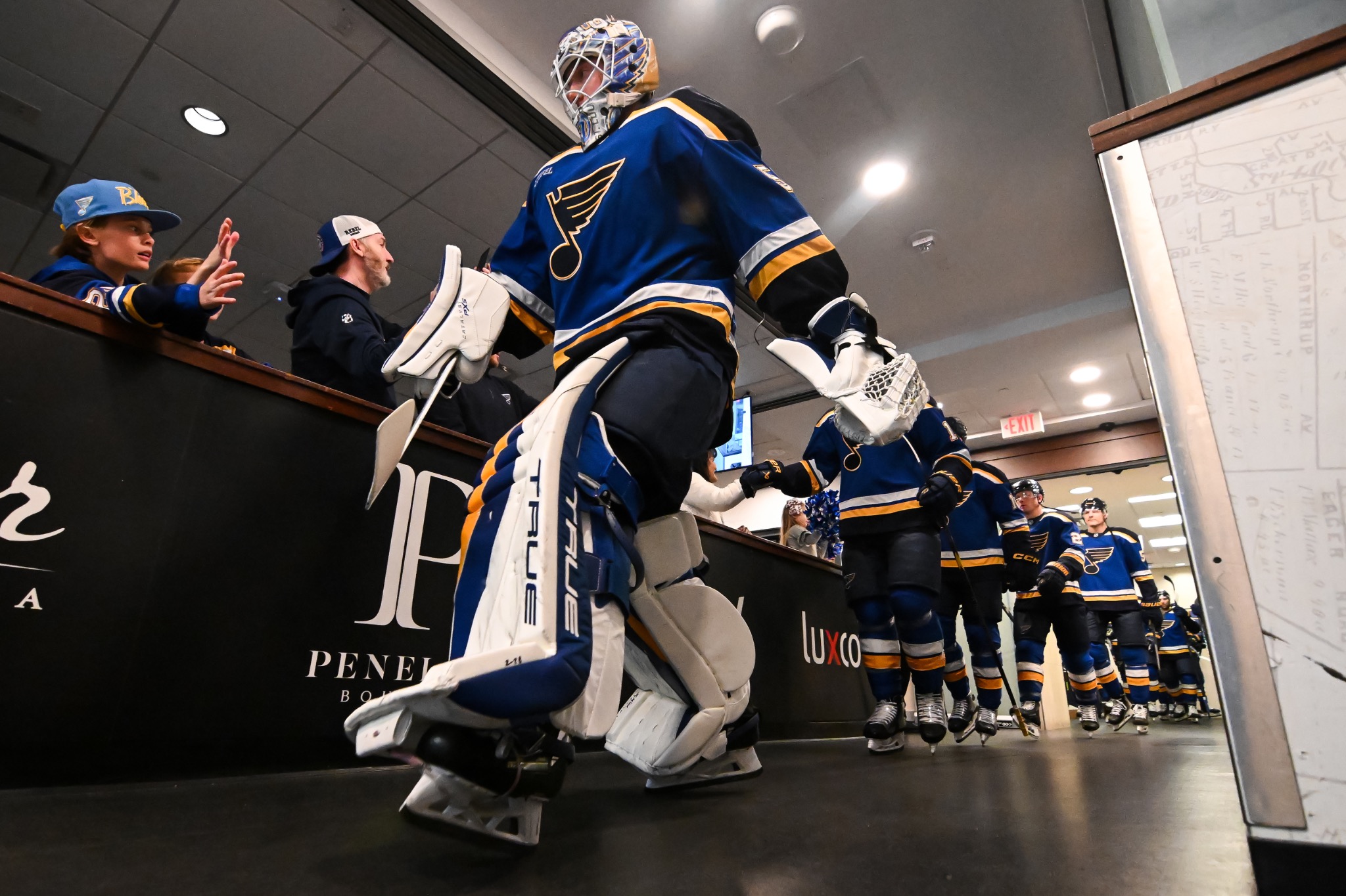 Professional hockey goaltender walking through an arena tunnel