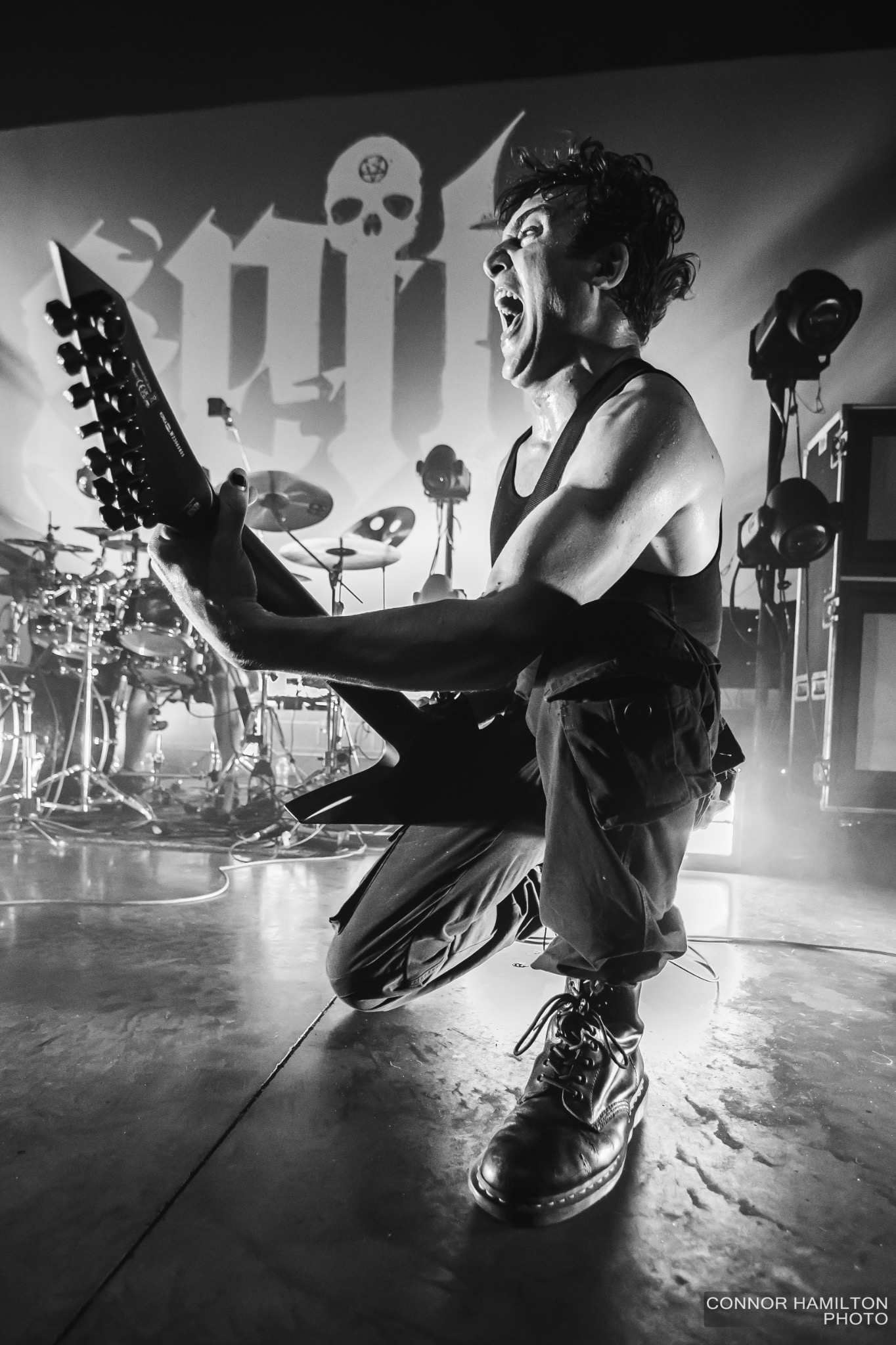 Black-and-white close view of a guitarist performing with intense energy