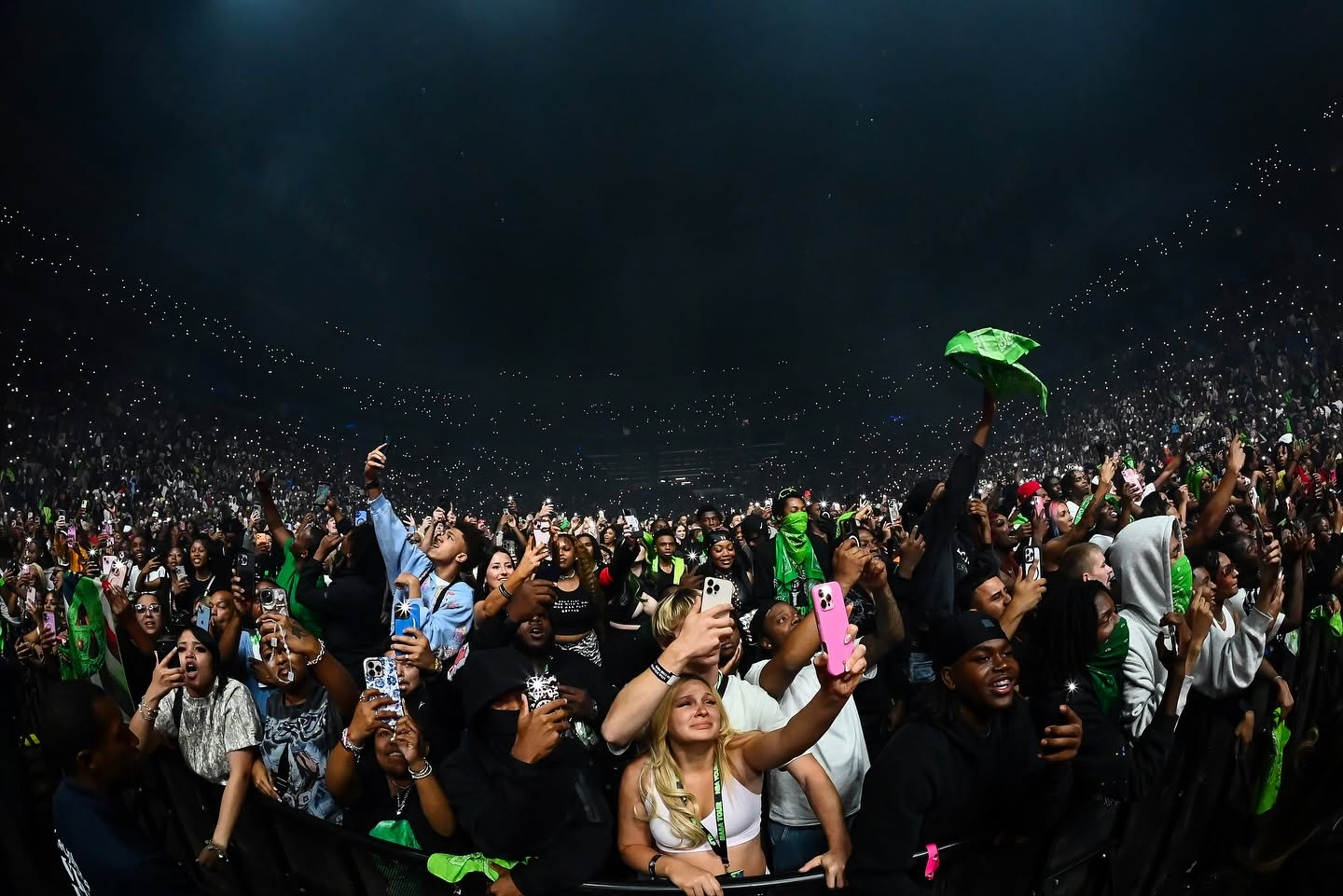 Large concert audience filling the venue from stage to rear floor