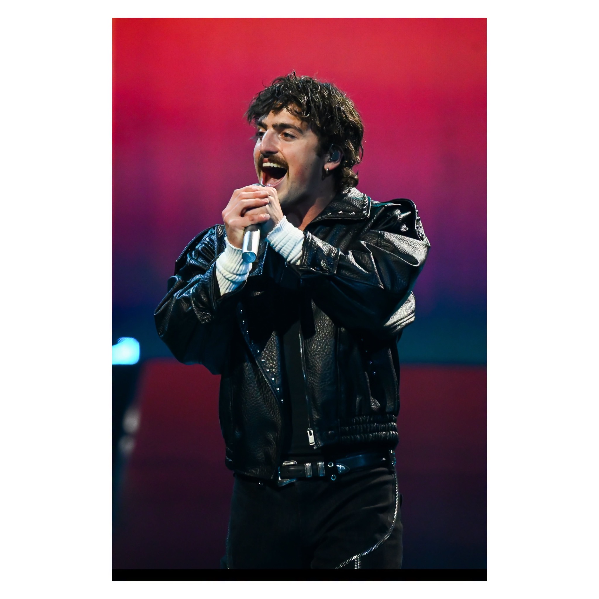 Vocalist holding a microphone during an emotional performance