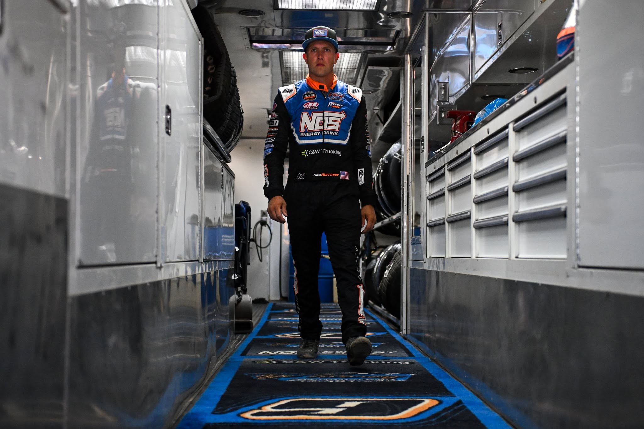 Race driver walking through the narrow aisle of a team hauler