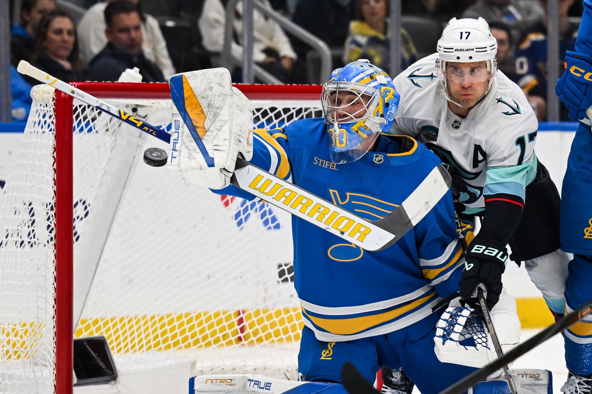 Hockey goaltender tracking the puck through traffic at the crease