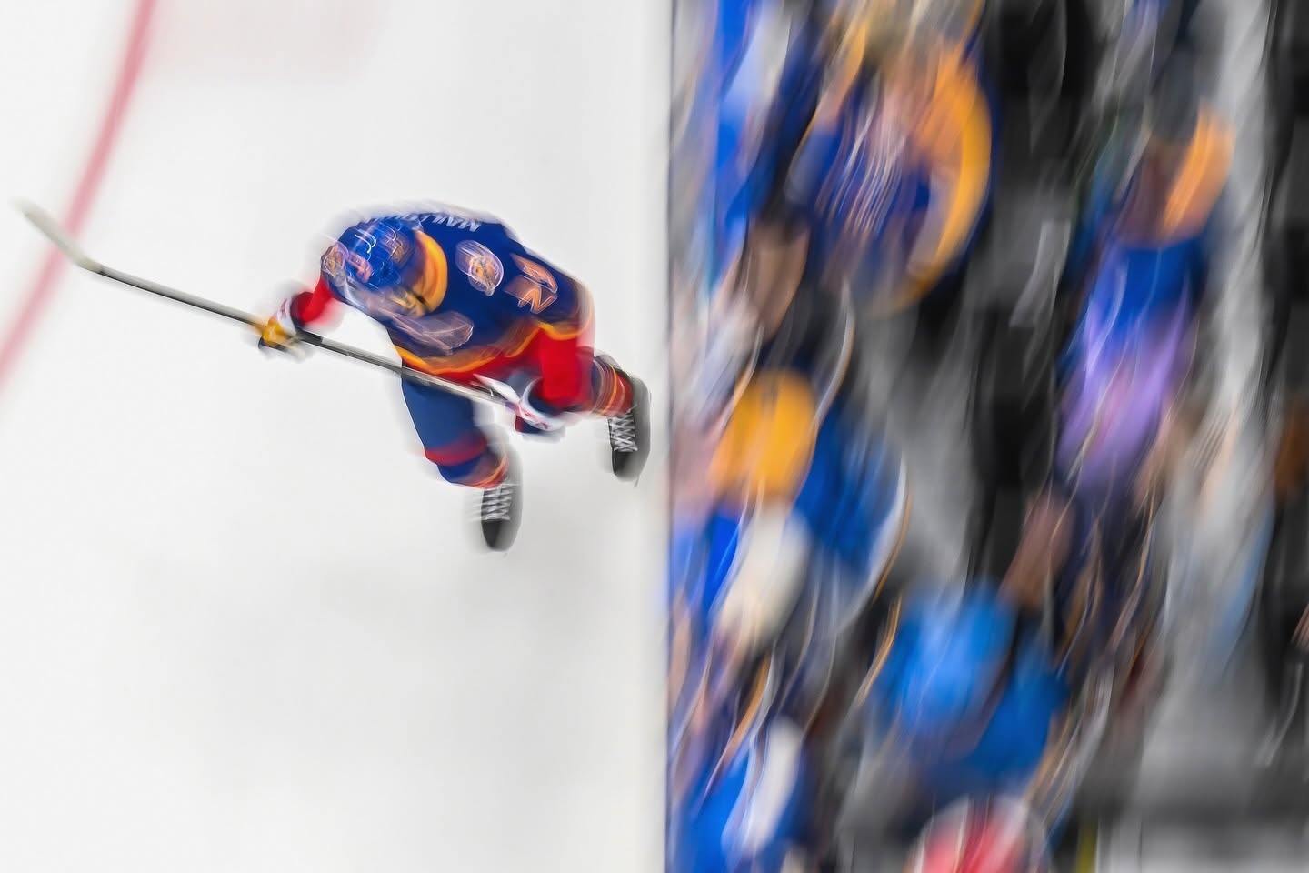 Hockey player rendered with intentional motion blur beside the bench