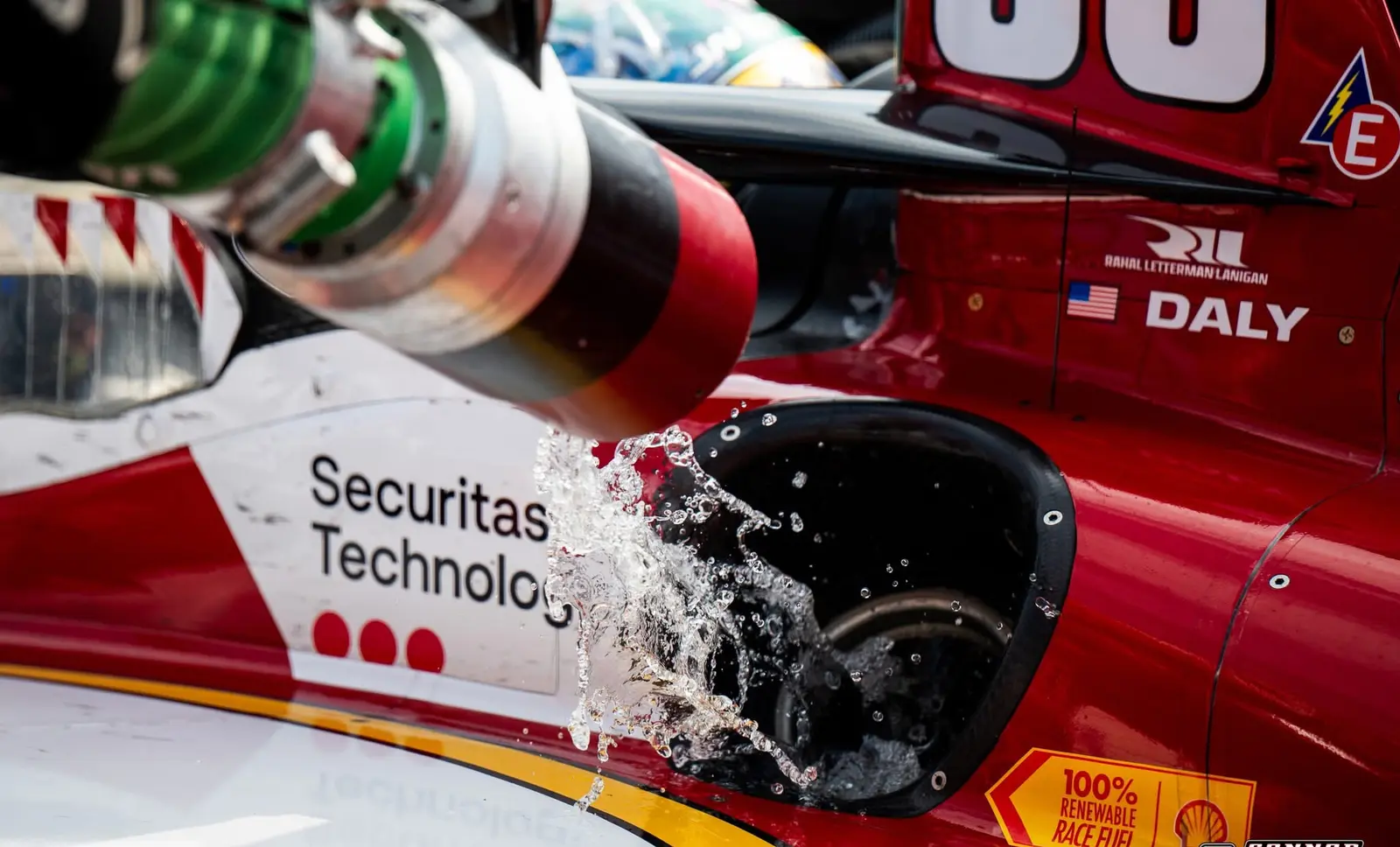 Close detail of fuel spilling around an IndyCar fuel port during pit service