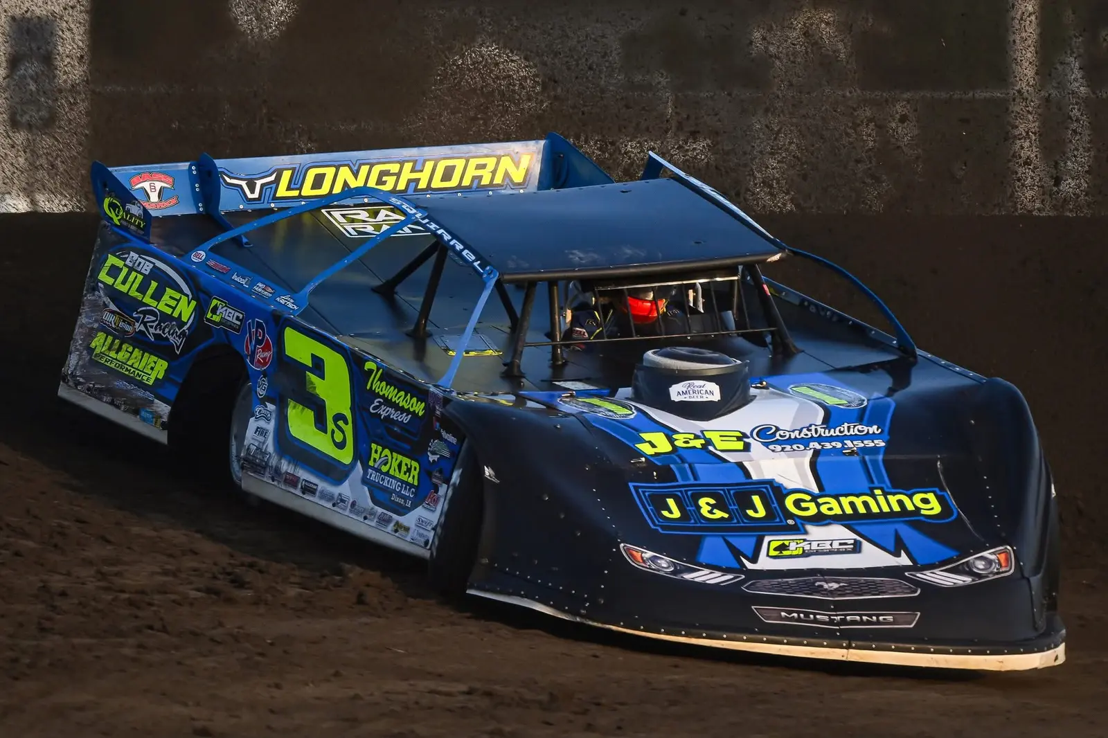 Blue number 3S dirt late model cornering on a dirt track