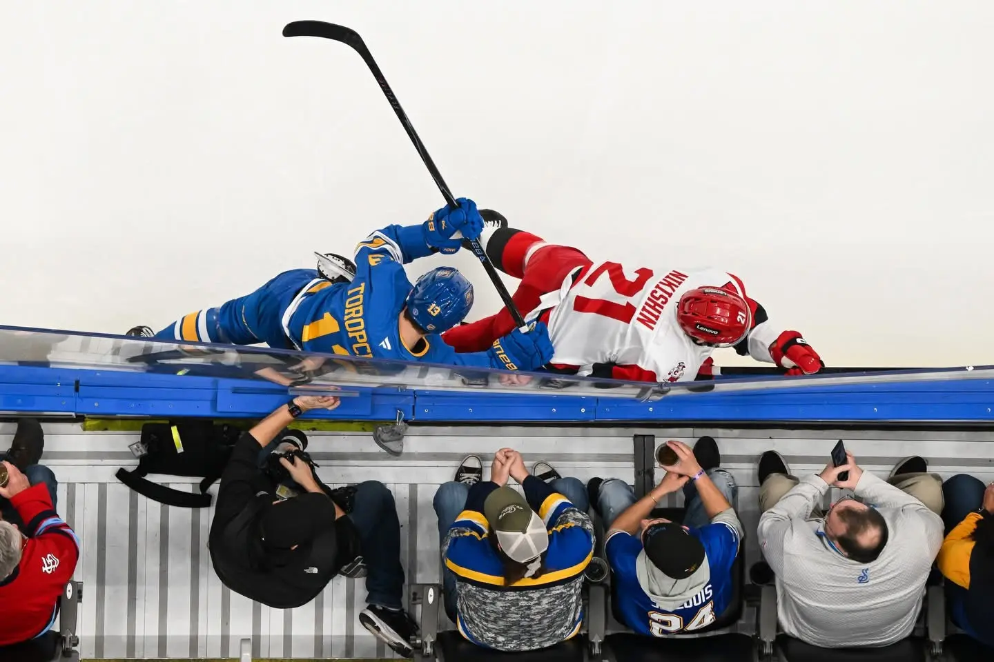 Overhead view of two professional hockey players colliding along the boards