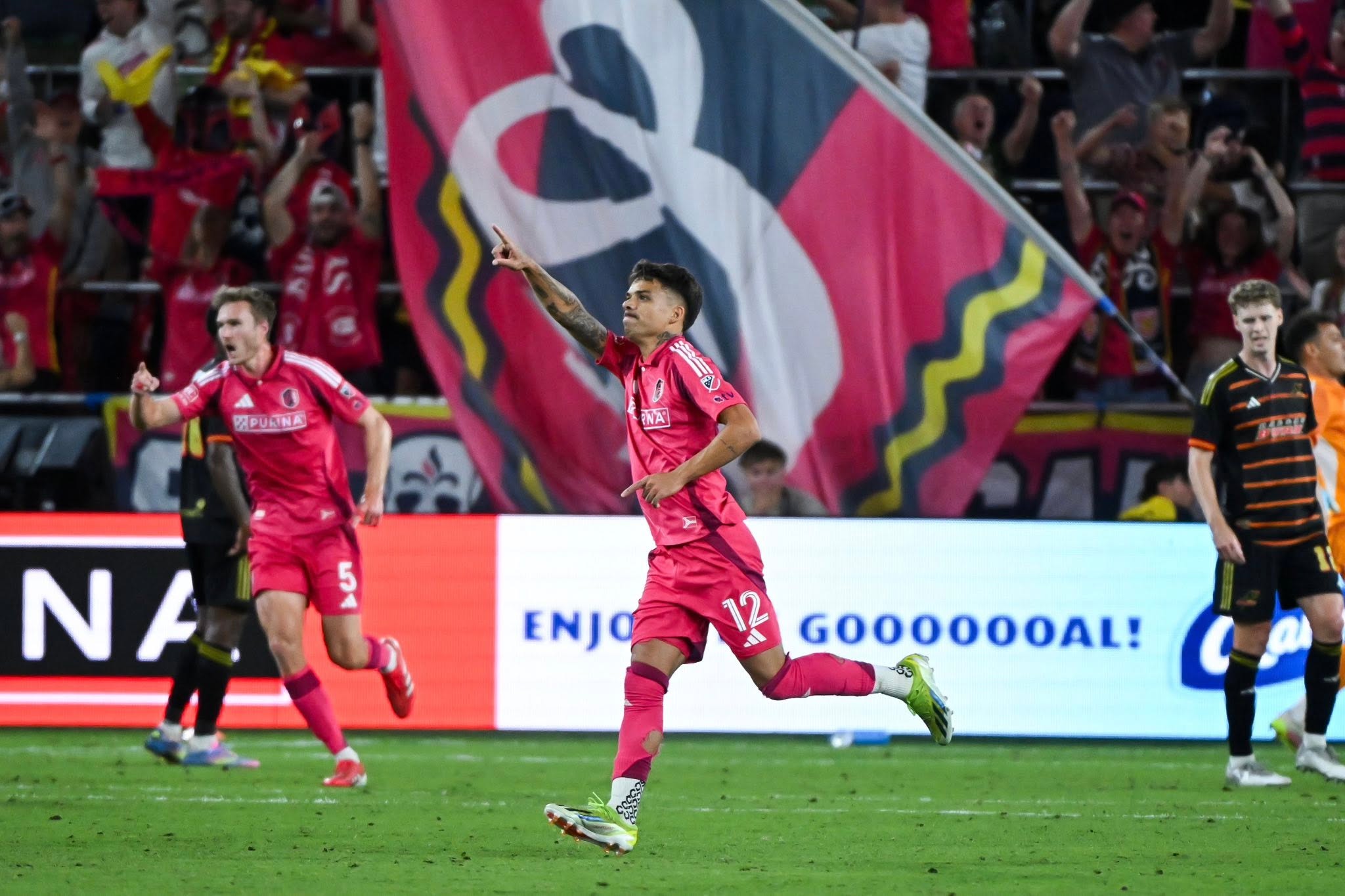 Professional soccer player celebrating a goal in front of supporters