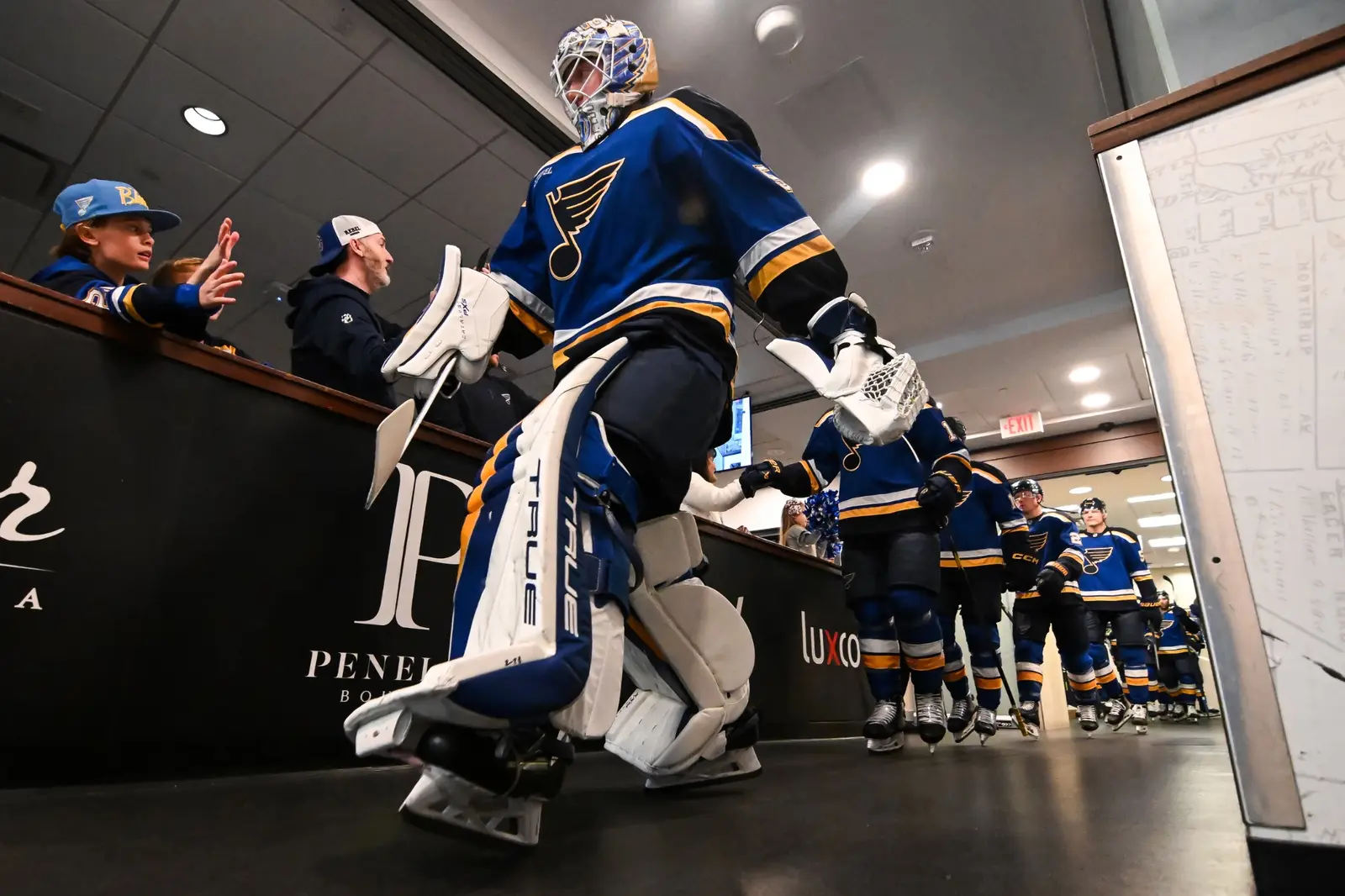 Professional hockey goaltender walking through an arena tunnel